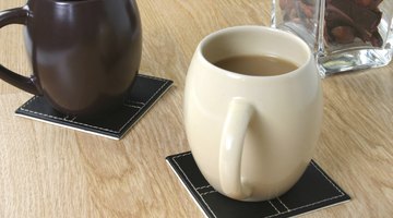Two hot coffee cups resting on tile coasters