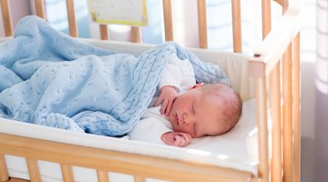 Cute baby boy in a white crib