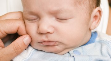 five-months baby closes mouth with hand