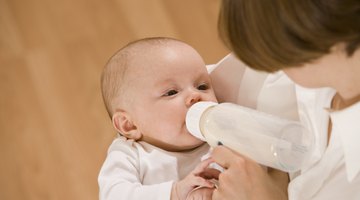 Woman feeding hungry baby with bottle