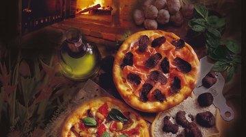 Pizza's are common foods cooked in a brick oven