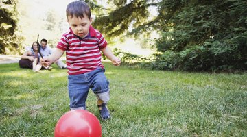 Five children (7-11) running with plastic hoops in park (surface level)