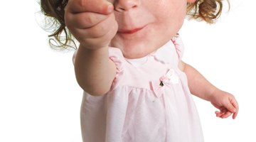 Cute baby with heart shaped lollipop at park