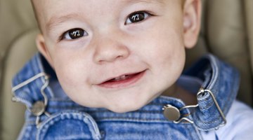 Father Dressed For Work Changing Baby's Diaper In Bedroom