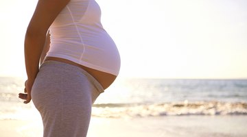 Belly of pregnant woman in sunset lights