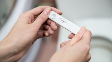 Smiling woman positive pregnancy test result
