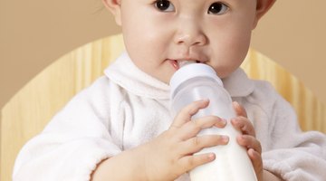 a newborn baby sucking a nursing bottle