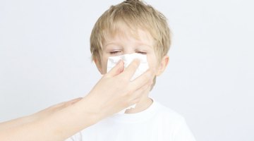 Sick little boy makes inhalation mask for breathing at home