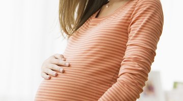 Pregnant young woman looking at her belly