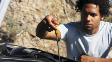 Man checking oil in car with dipstick