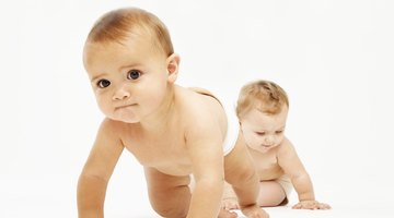 Female baby (6-9 months) crawling towards camera as another baby playing behind