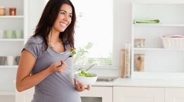Pregnant woman eating  fresh healthy salad