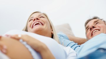 Woman holding hands in heart on pregnant stomach
