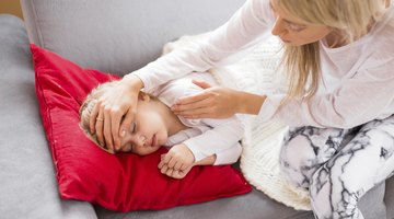 Baby ailing and lying with thermometer