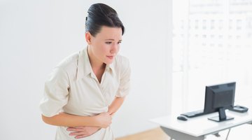 Pregnant Woman Sits in the Lotus Position on a Carpet