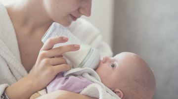 a newborn baby sucking a nursing bottle