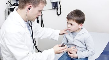 Doctor holding stethoscope to toddler boy's (18-21 months) chest