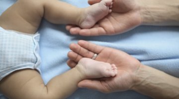 sleeping baby in hand of mother