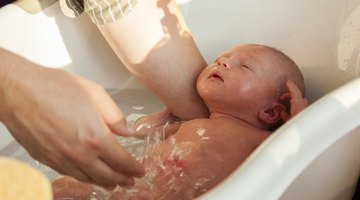 Close-up of a baby boy getting a bath from his mother
