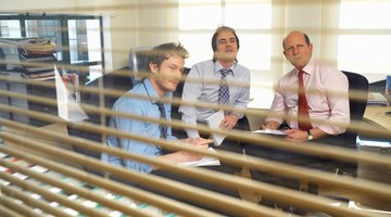 Men having meeting behind blinds.