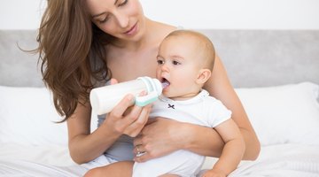 High angle view of a mature man feeding his baby with a bottle