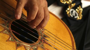 A close-up of a man playing a Spanish guitar.