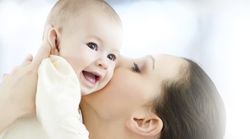 Close Up Of Mother Cuddling Sleeping Baby Daughter At Home