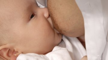 Baby girl (6-9 months) lying by mother, laptop, diary and mobile phone