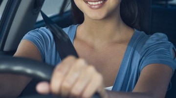 Woman using gearshift in car, close-up of hand, mid section