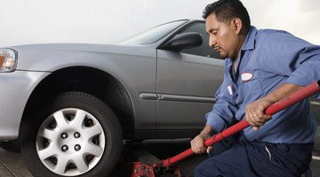 Young woman changing a flat tyre