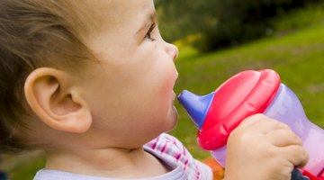Infant Girl Holding a Plastic Beaker