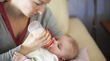mother bottle feeding baby son (6-12 months)