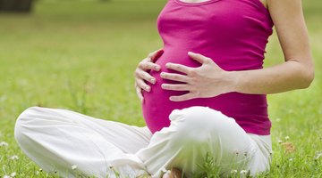 Pregnant woman holding pills and glass of water