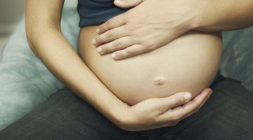 Pregnant woman working at home with young son