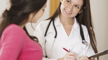 Side profile of a female doctor examining a baby boy with a stethoscope