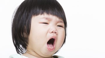 Newborn baby crying on the bed