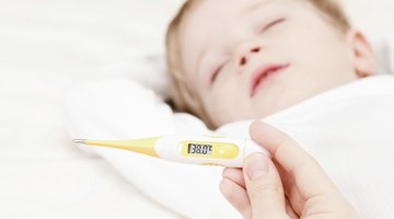 Baby ailing and lying with thermometer