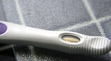sad young woman holding pregnancy test
