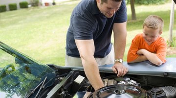 Father and son looking at car engine