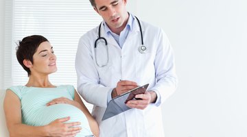 Pregnant woman looking at growing stomach