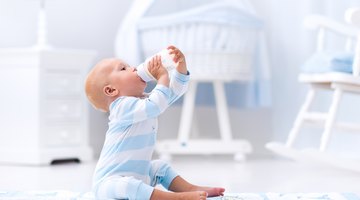 Infant Girl Holding a Plastic Beaker