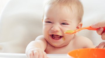 Asian baby boy eating blend food on a high chair