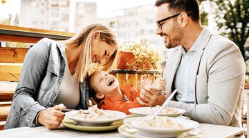 Boy sitting on couch with aloof parents