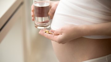 Pregnant Woman Hand With Glass Of Water And Vitamin Pill