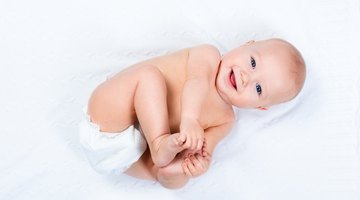 Baby playing with father as diaper is changed