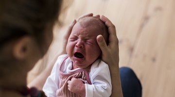 young mother breast feeding her baby girl at sunny day