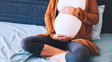 Belly of pregnant woman in sunset lights