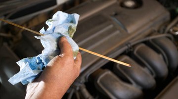 Man checking oil in car with dipstick