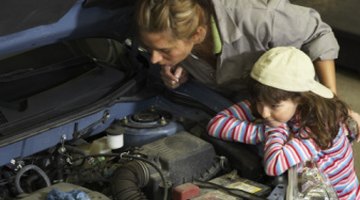 Two young men looking into the engine bay of a vehicle