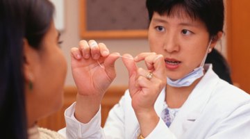 Una dentista demostrando el uso adecuado del hilo dental.